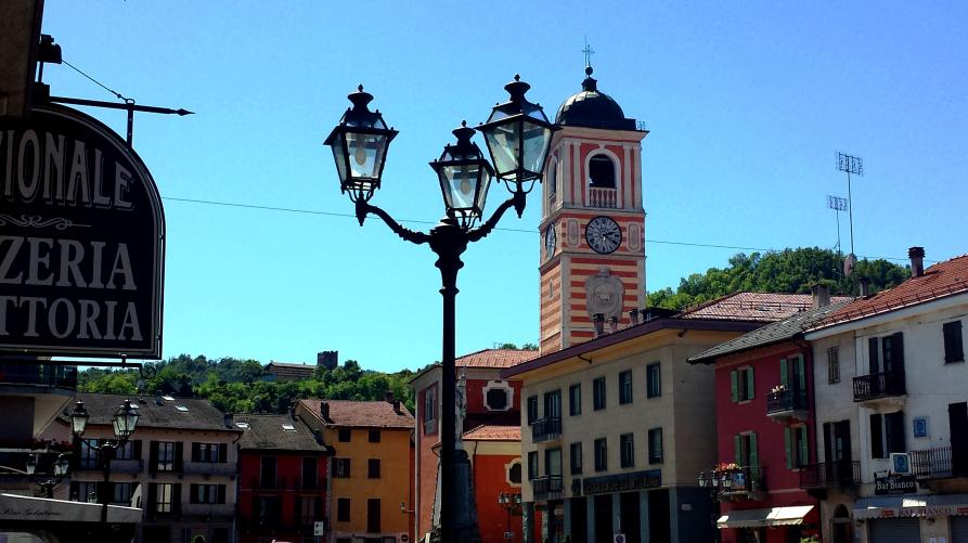 Boves (CN). Scorcio di Piazza Italia e dei suoi edifici colorati con a sinistra un'insegna storica di un esercizio commerciale. Al centro un lampione storico. Fotografia di Giorgio Vannuccini. 