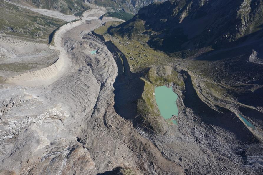 Ghiacciaio del Belvedere su cui si riconosce in lontananza il lago epiglaciale osservato dal 2018; a destra in primo piano il Lago delle Locce
