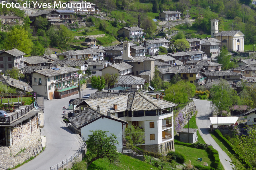 Rorà (TO). Vista dall'alto del paese. I tetti di pietra grigia sono messi in risalto dalla vegetazione primaverile. Fotografia di Yves Mourglia tratta dal sito del Comune (2018-2020) 