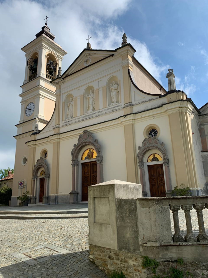 Mornese (AL). Visione frontale della Chiesa di San Silvestro. Chiesa e campanile sono dipinti di bianco e color crema. Lo stile è Barocco 