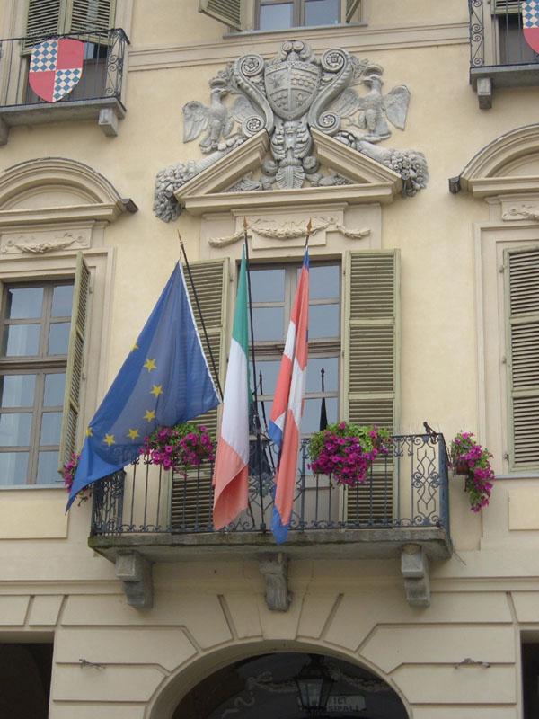San Damiano d'Asti (AT). Il Municipio. Particolare della facciata con bandiere esposte 