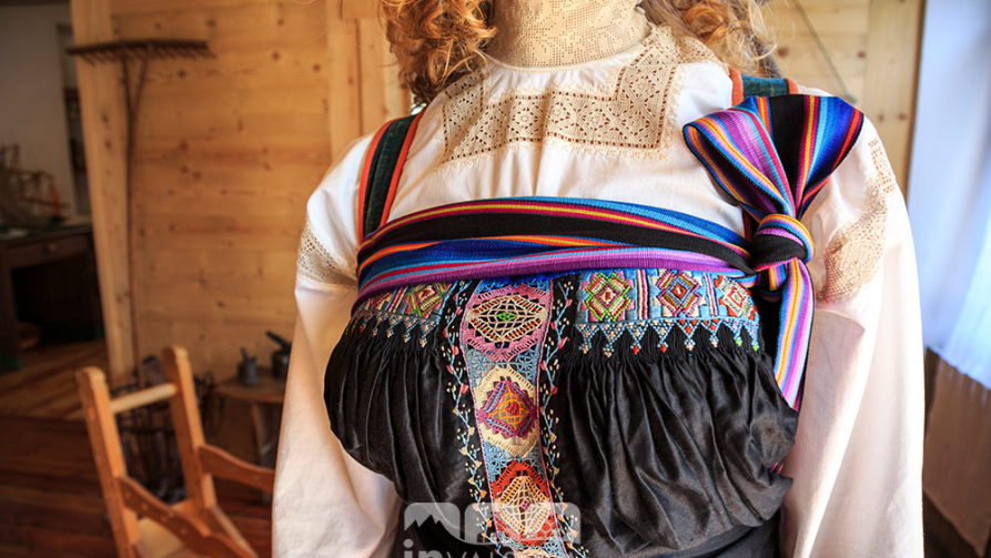 Fobello (VC). Particolare di un corsetto femminile Walser nero riccamente ricamato con fili multicolore. Sotto il corsetto una camicia bianca ricamata con filo beiges 