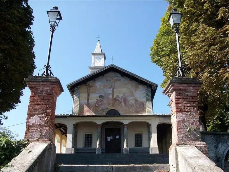 Borgo San Dalmazzo (CN). Scalinata in primo piano del Santuario del Monserrano. La facciata è inquadrata fra due colonne sormontate da lampioni. Immagine tratta dal sito del Comune (2025) 