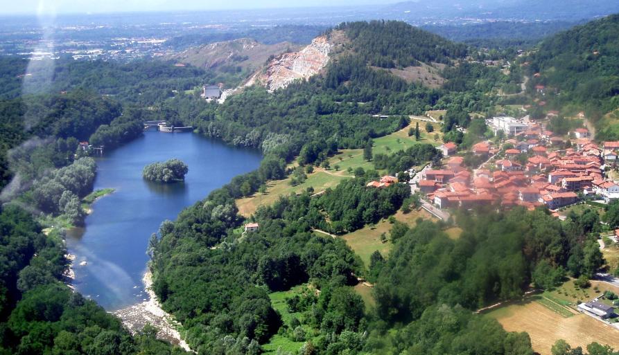 Vidracco (TO). Panoramica aerea. A destra i tetti rossi del paese e a sinistra il lago artificiale blu immerso nella ricca vegetazione. Fotografia tratta dal sito del Comune (2025) 