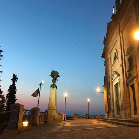 Bruno (AT). Al tramonto. Dal Belvedere Don Andrea Ivaldi si può ammirare un cielo blu scuro con sfumature rosa messo in risalto dalle luci pubbliche appena accese. Immagine tratta dal sito del Comune 