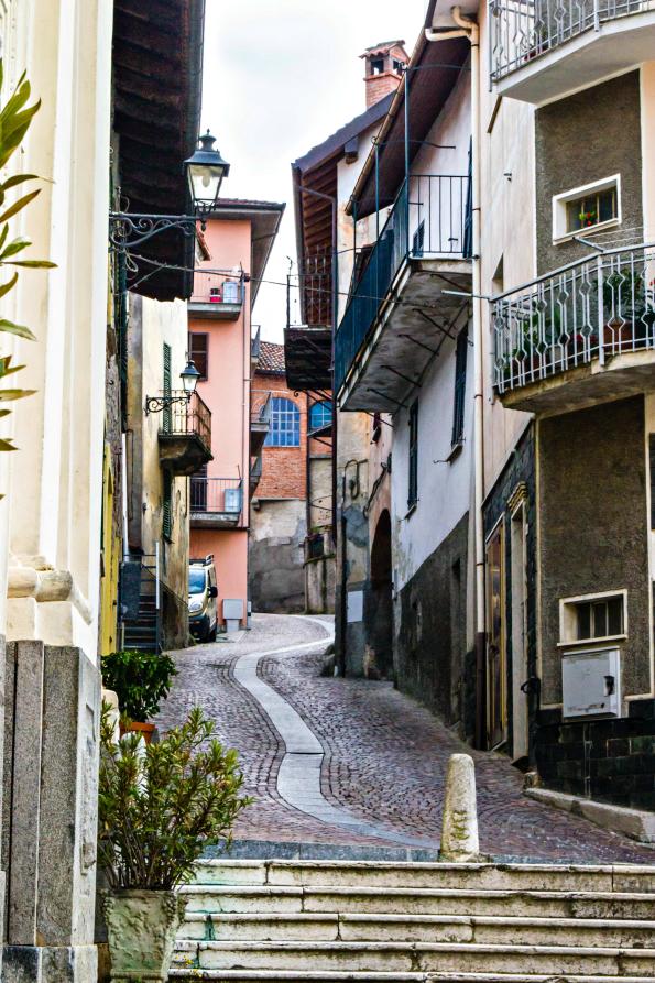 Castelletto d'Orba (AL). Scorcio del paese. La via stretta lastricata in porfido divide in due le case (2014) 