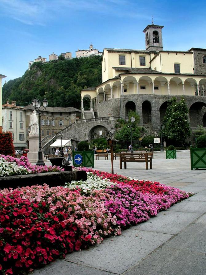 Varallo (VC). In primo piano aiuole fiorite nella piazza e in alto la Collegiata di San Gaudenzio 