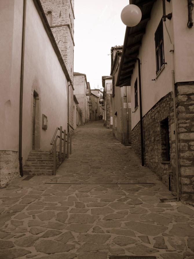 Levice (CN). Il vicolo lastricato a lose in salita divide i caseggiati a due piani del centro storico. Fotografia in bianco e nero di Monica Francone (2006) 