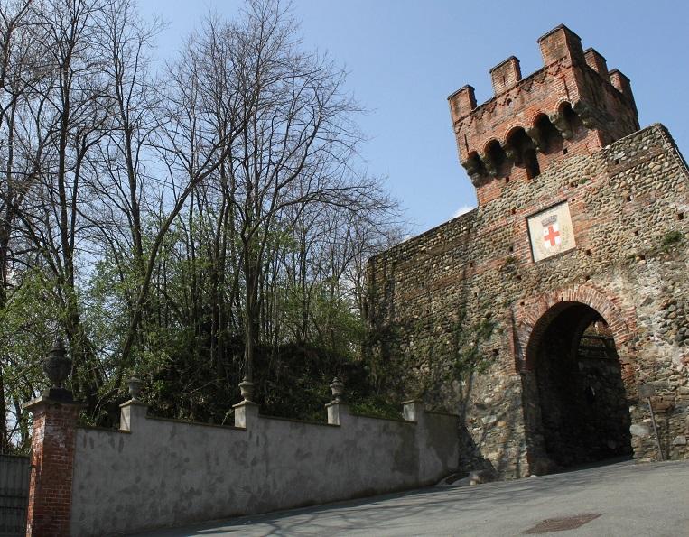 Salussola (BI). Porta urbica. A sinistra un muro con alti alberi porta alla porta urbica con ampio arco e torre merlata. Fotografia di Claudio Circolari (2015) 