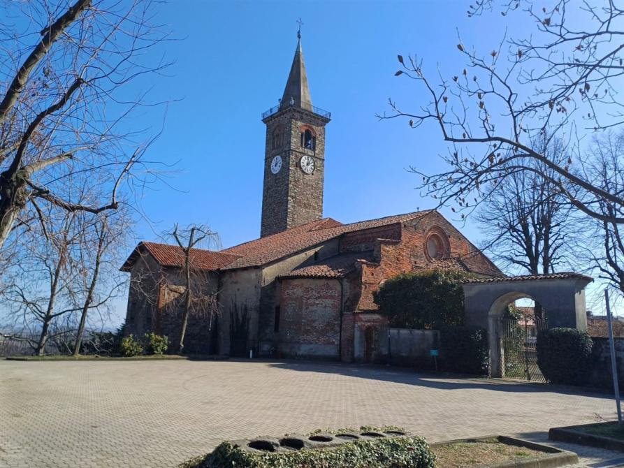 Salussola (BI). La Chiesa di Santa Maria Assunta in mattoni rossi e dal campanile in pietra grigia con guglia esagonale si staglia nel cielo azzurro. Immagine tratta dal sito del Comune (2025) 