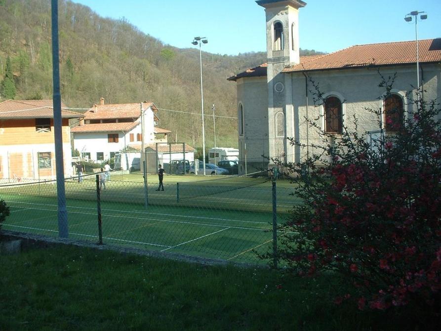 Camandona (BI). Il Centro sportivo affianca la Chiesa in frazione Pianezze. Sullo sfondo gli alberi spogli a contrasto col cielo azzurro e limpido. Fotografia di Ilario Guelpa Piazza 