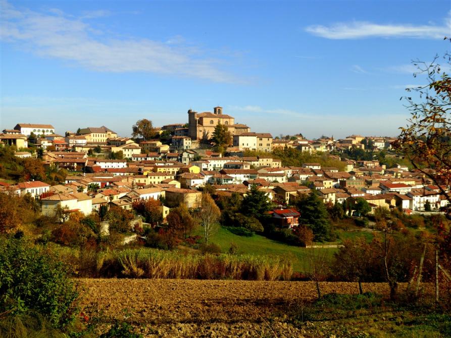 Casorzo Monferrato (AT). Dal campo arato si intravede il paese e la natura autunnale.  