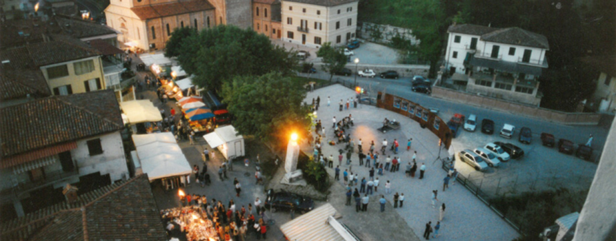 Farigliano (CN). Vista dall'alto all'imbrunire della piazza centrale e dei banchi allestiti con luminarie in occasione della Fiera del Puciu 