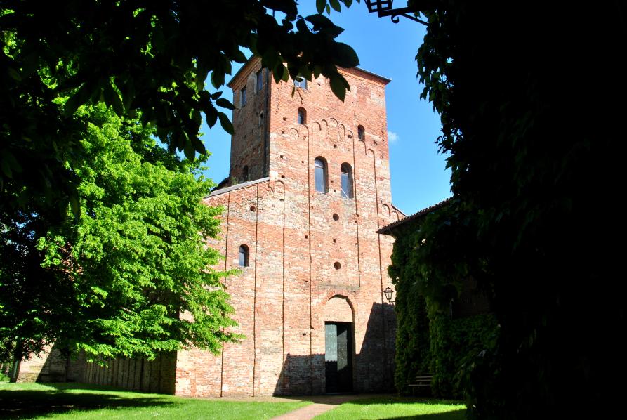 Sezzadio (AL). Tra le fronde degli alberi appare la facciata romanica dell'Abbazia di Santa Giustina . Fotografia di Barbara Ricagno (2015) 