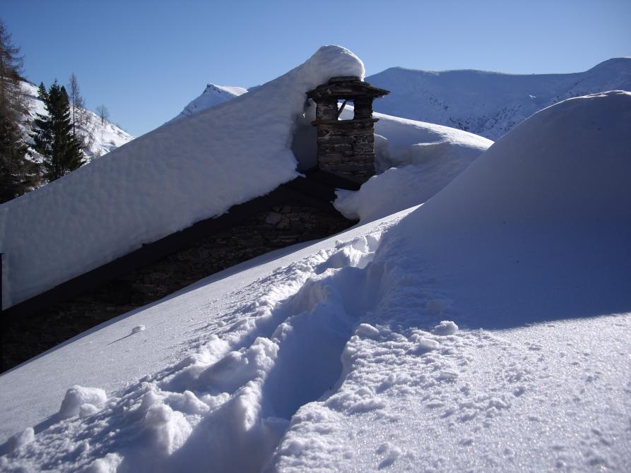Castelmagno (CN). Scorcio dei tetti sommersi dalla neve di Frazione Chiappi. Fotografi a di Beppe Garnerone 