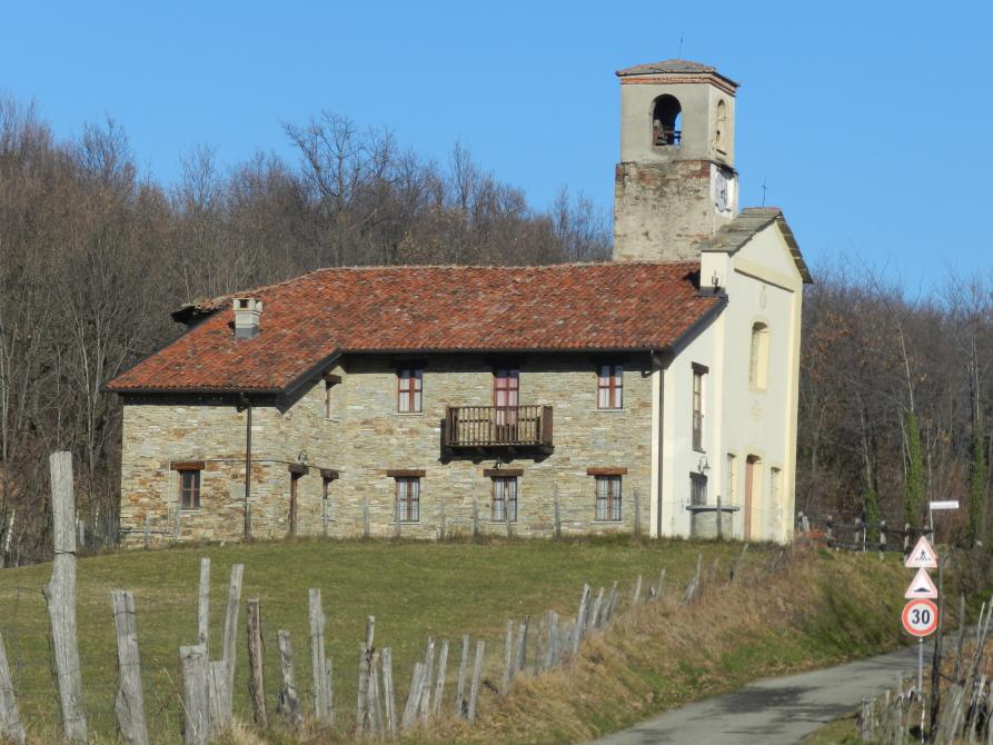 Bricherasio (TO). Vista laterale della chiesetta di Santa Caterina d'Alessandria. Sullo sfondo alberi spogli e un cielo perfettamente limpido 