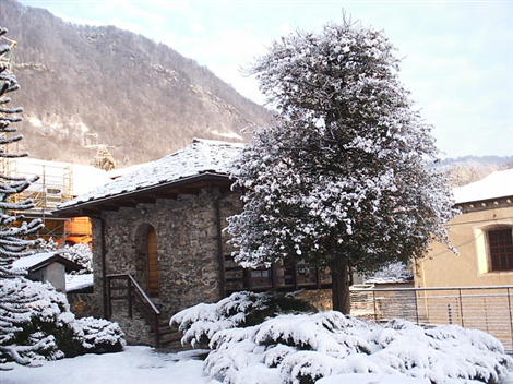 Nonio (VCO). Paesaggio invernale con casupola e albero ricoperti dalla neve. Immagine tratta dal sito del Comune (2025) 