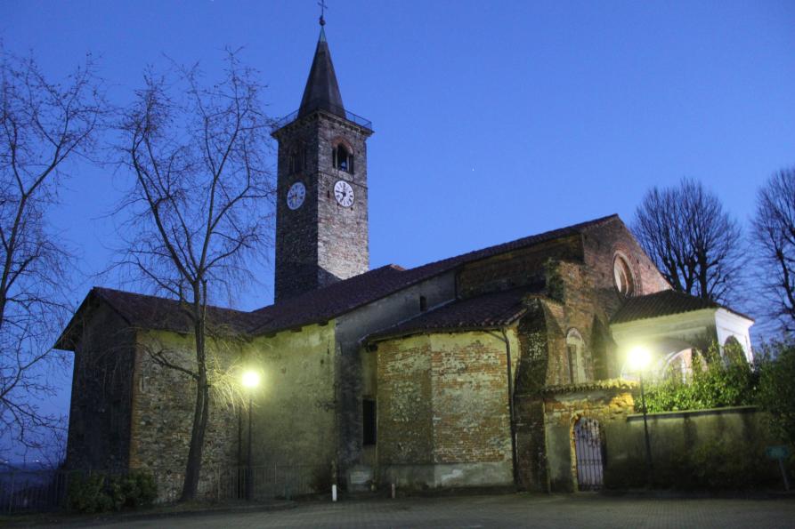 Salussola (BI). All'imbrunire la Chiesa romanico-gotica di Santa Maria Assunta, illuminata da due lampioni, ha alle spalle un cielo blu cobalto intenso. Fotografia di Claudio Circolari (2015) 