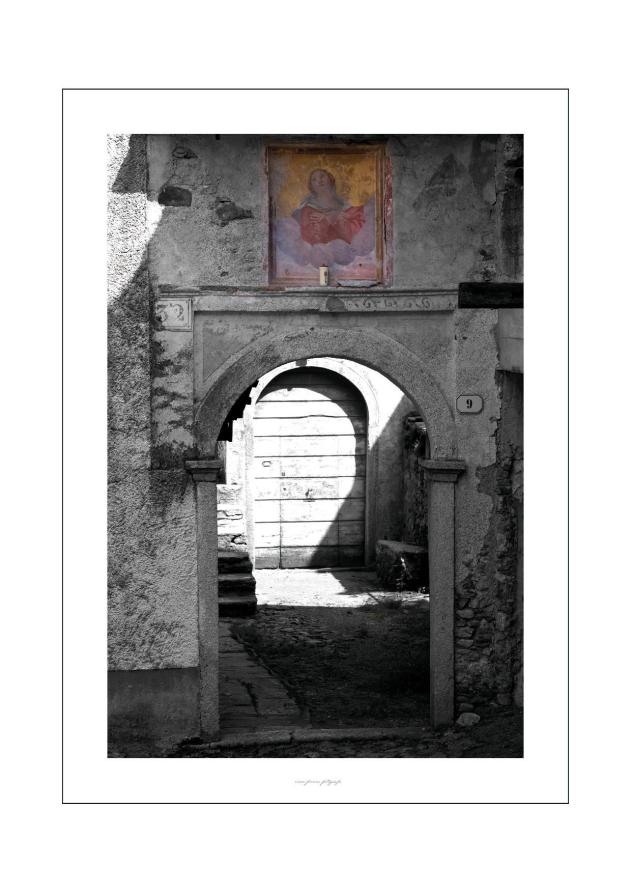 Arola (VCO). Affresco su abitazione. L'immagine è in bianco e nero e l'affresco è valorizzato con i colori. Fotografia di Enzo Franza (2013) 