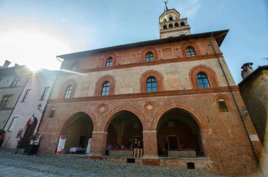 Saluzzo (CN). Antico Palazzo comunale in stile gotico in mattoni a vista con porticato con tre archi. Al secondo e terzo piano finestre con arco a sesto acuto. Immagine tratta dal sito del Comune (2026) 