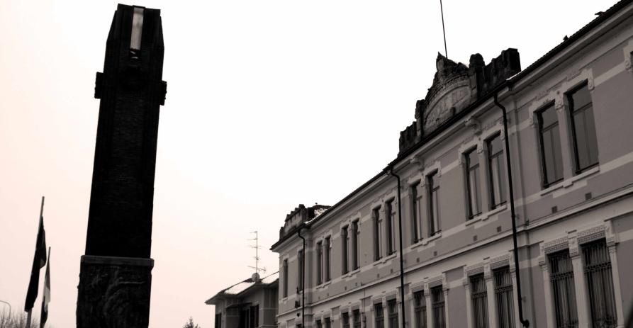 Caresana (VC). Scorcio in bianco e nero delle scuole elementari e a sinistra il monumento ai caduti in primo piano. Fotografia di Andrea Cherchi (2009) 