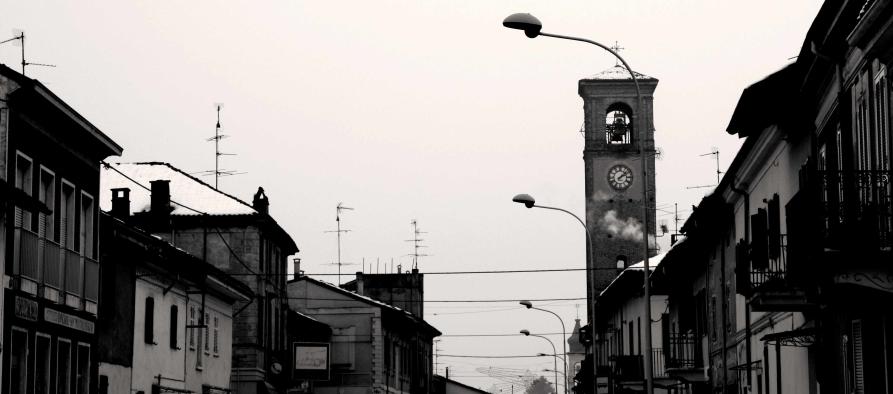 Caresana (VC). Fotografia in bianco e nero che ritrae gli edifici del paese e il campanile a destra di una chiesa. Fotografia di Andrea Cherchi (2009) 