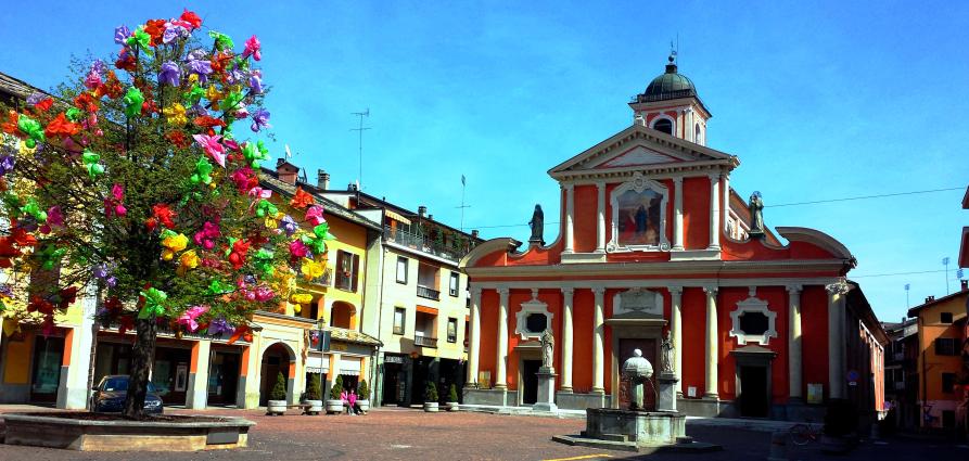 Boves (CN). A sinistra l'olmo storico con decorazioni colorate in occasione delle festività pasquali. Al centro la Chiesa di San Bartolomeo dipinta di rosso e bianco. Fotografia di Giorgio Vannuccini 