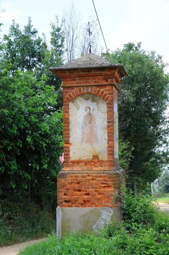 Sanfrè (CN). Lungo un sentiero sterrato compare un capitello religioso in mattoni scoperti con immagine sacra affrescata 