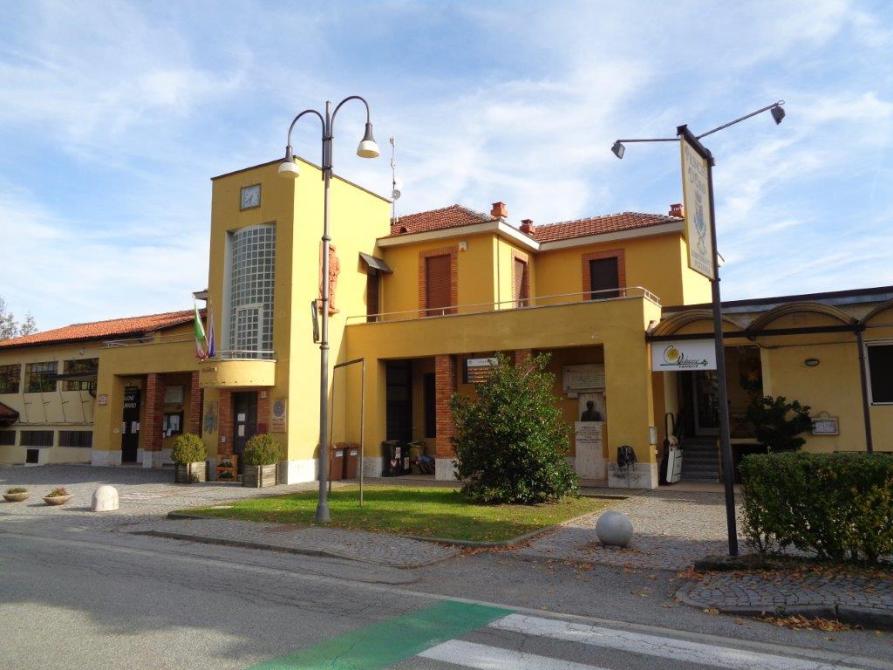 Vidracco (TO). Il Municipio è una costruzione dalle forme squadrate a due piani dipinta di giallo. Il cielo è nuvoloso  