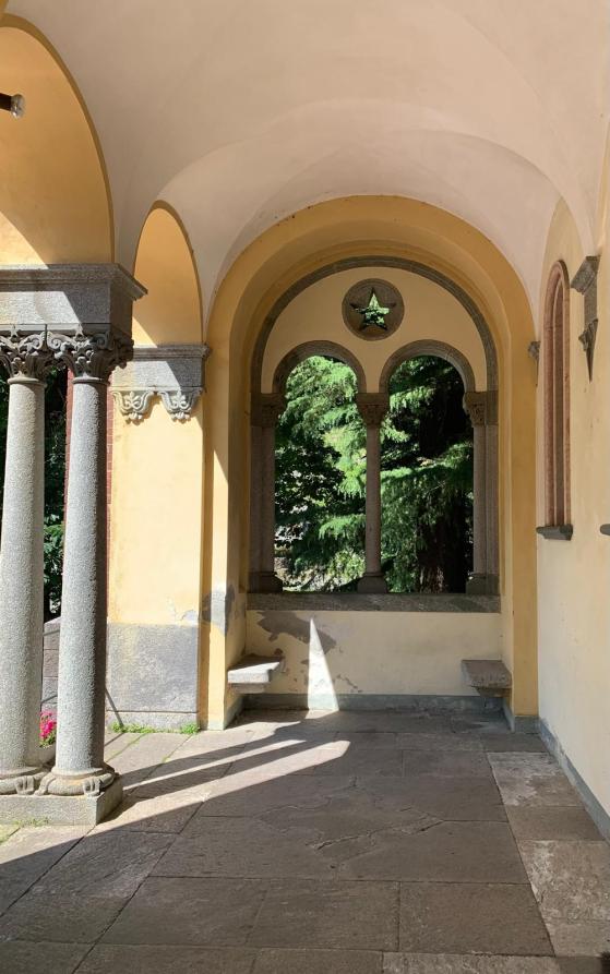 Rosazza (BI). Loggiato all'entrata dalla Chiesa dei Santi Pietro e Giorgio con colonne binate in pietra grigia e al fondo una bifora sormontata da una piccola apertura a forma di stella 