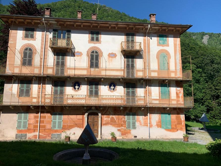 Rosazza (BI). Edificio a quattro piani con balconate in ferro dipinto con finestre, cornici e pietre trompe l'oeil  