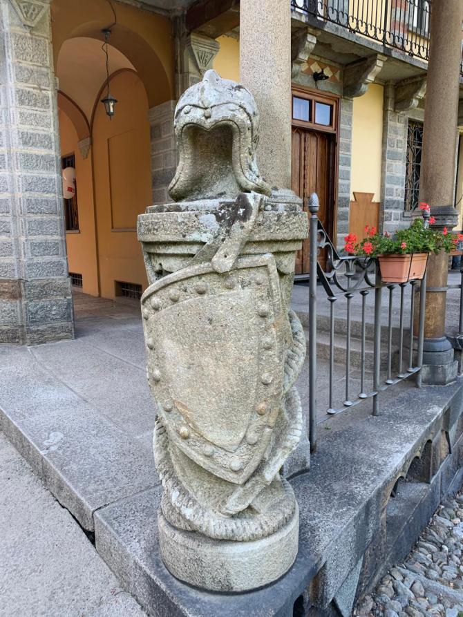 Rosazza (BI). Scudo e elmo militari in pietra posti a decorazione di una delle colonne del Municipio 