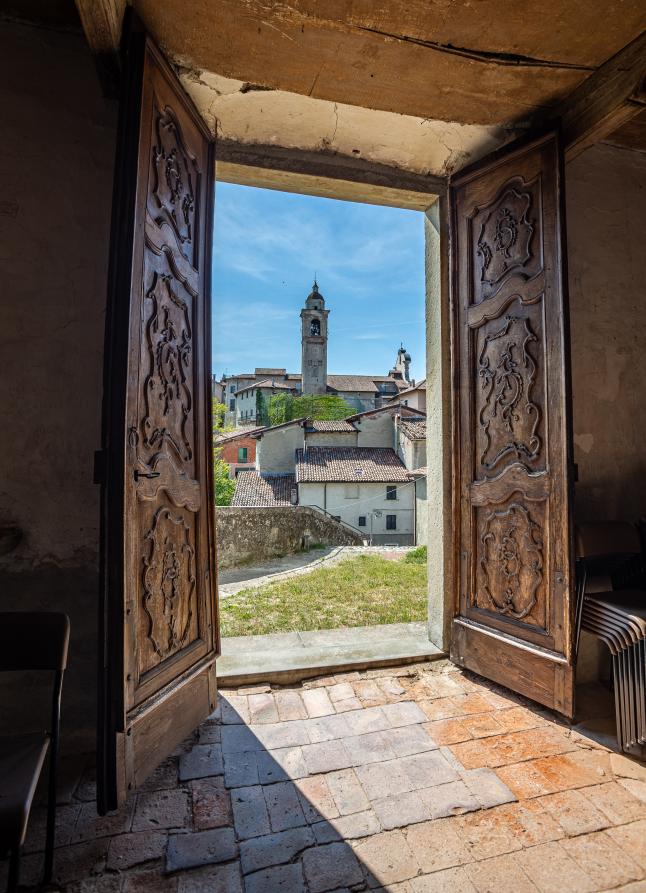 Rocca Grimalda (AL). Da un portone spalancato appare uno scorcio su Castelvero 