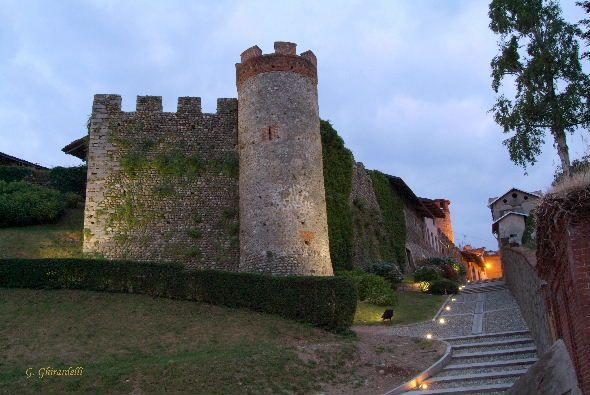 Candelo (BI). E' l'imbrunire. Il Ricetto è illuminato da faretti anche lungo la salita in ciottoli 