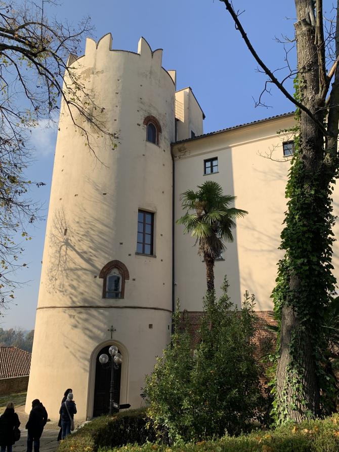 Cortanze (AT). Particolare della torre merlata del castello e scorcio del parco verdeggiante 